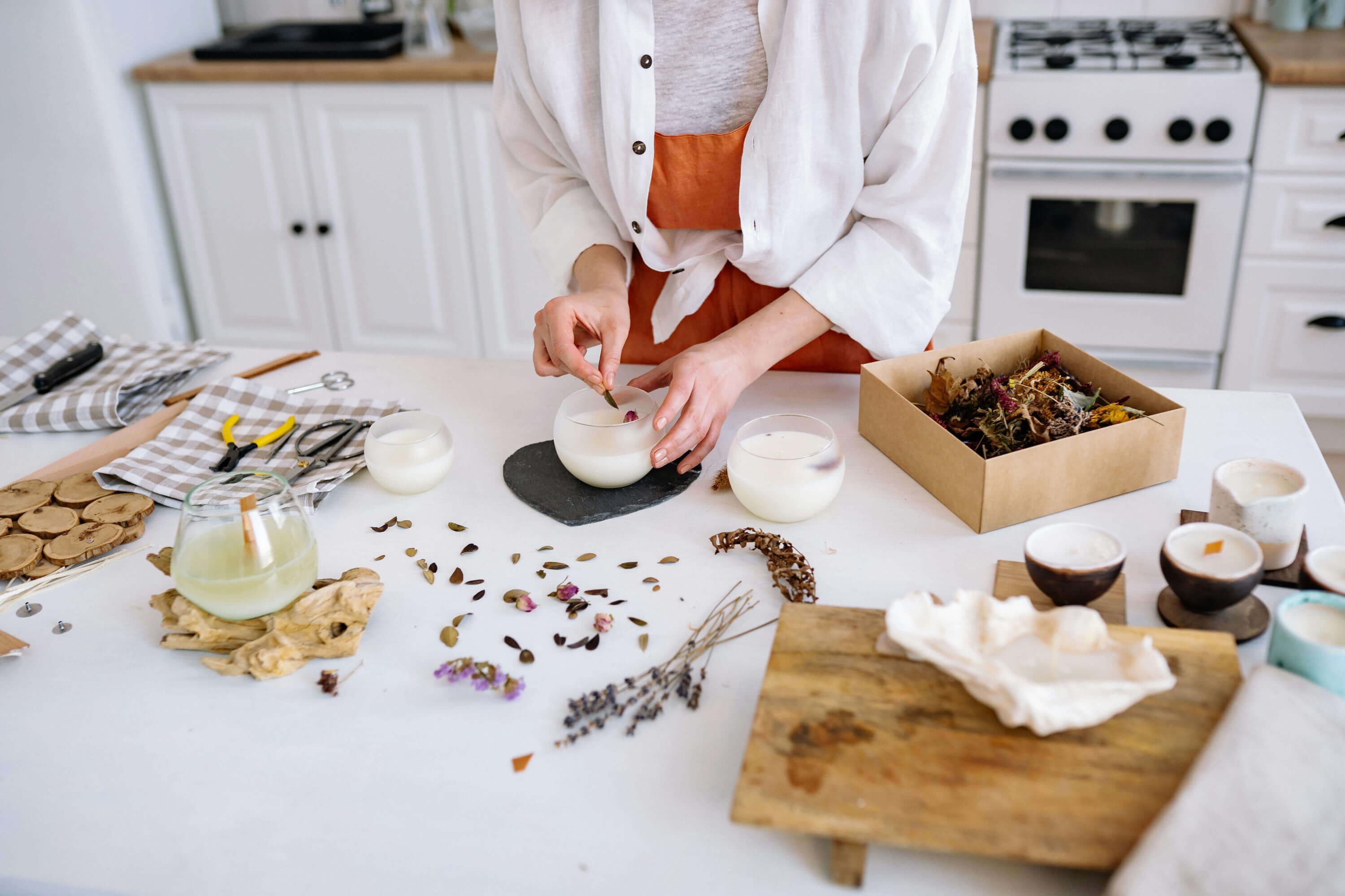 A soy candle being poured into an 8oz amber jar on a domestic kitchen bench